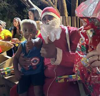 Menino sentado no colo do Papai Noel, na Cidade dos Anjos (Foto: Divulgação/Projeto Girassol)