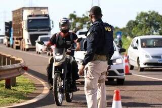 Policial rodoviário abordando motociclista durante blitz educativa, no dia 19 de dezembro (Foto: Henrique Kawaminami)