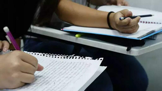 Estudante escreve redação teste em folha de papel. (Foto: Arquivo/Campo Grande News)