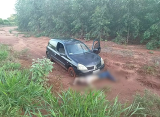 Corpo de João em frente ao carro, na estrada em que foi encontrado (Foto: RCN 67)