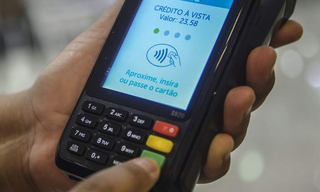 Consumidor passa cartão de crédito em máquina eletrônica no comércio. (Foto: Marcello Casal Jr/ Agência Brasil)