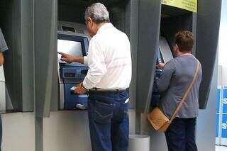 Idosos utilizam caixa eletrônico (Foto: Marcos Santos/Banco de imagens da USP)