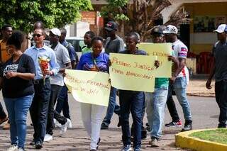 Com cruz, velas e flores, grupo protesta contra viol&ecirc;ncia ap&oacute;s morte de haitiano