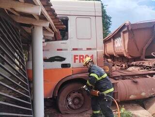 Motorista perde controle de caminh&atilde;o, invade casa e fica retido em cabine