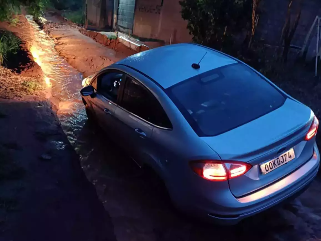 Motorista de app tem carro atolado em cratera ap&oacute;s chuva na Capital