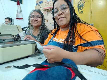 M&atilde;e e filha se apoiam e encontram nas agulhas de costura um recome&ccedil;o