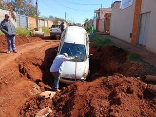 Idoso tenta passar por rua em obras e cai com o carro em um buraco