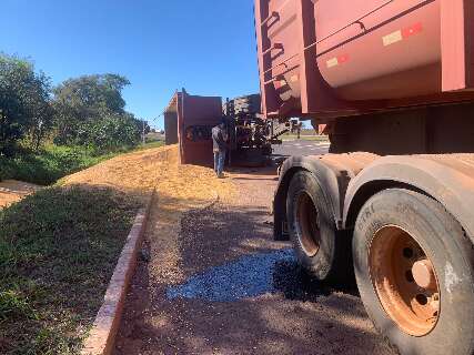 Carreta carregada com milho tomba e espalha carga &agrave;s margens da pista
