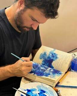 Arthur faz pintura em aquarela sobre as poesias de Manoel de Barros