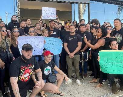 Com cartaz &quot;seu cargo &eacute; tempor&aacute;rio&quot;, professores protestam contra corte de b&ocirc;nus