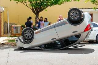 Motorista capota após atingir três carros estacionados em cruzamento Motorista capota após atingir três carros estacionados em cruzamento