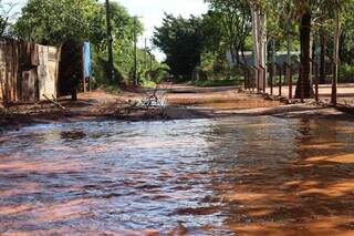 Carro ficou pelo caminho em rua encoberta por lama e &aacute;gua no Ch&aacute;cara dos Poderes