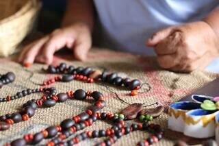 Para livrar cliente de mau-olhado, Dona Hildinha benze colares &agrave; venda