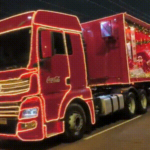 Caminh&otilde;es da Coca-Cola colorem a noite pelas ruas da cidade