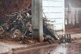 Ap&oacute;s chuva intensa, rua amanhece com barro, lixo e at&eacute; para-choque perdido