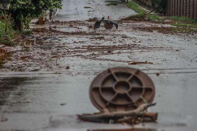 Ap&oacute;s chuva intensa, rua amanhece com barro, lixo e at&eacute; para-choque perdido