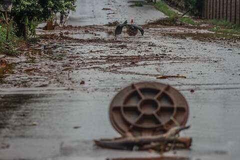 Ap&oacute;s chuva intensa, rua amanhece com barro, lixo e at&eacute; para-choque perdido