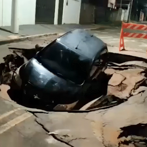 &ldquo;Para-choque foi pro pau&rdquo;: carro cai em cratera aberta ap&oacute;s forte chuva