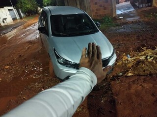 Carro fica preso em cratera durante corrida de aplicativo e ocupantes ficam a p&eacute;