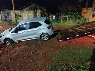 Carro fica preso em cratera durante corrida de aplicativo e ocupantes ficam a p&eacute;
