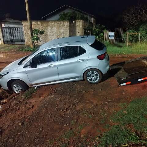 Carro fica preso em cratera durante corrida de aplicativo e ocupantes ficam a p&eacute;