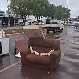 Revoltados com alagamentos, moradores espalham m&oacute;veis destru&iacute;dos em avenida