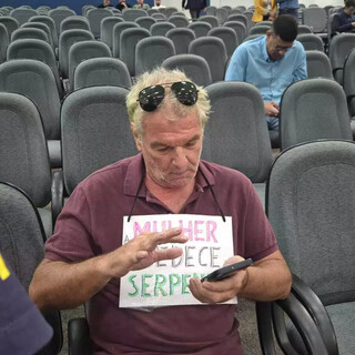 Manifestante com cartaz &ldquo;Mulher obedece a serpente&rdquo; &eacute; retirado da C&acirc;mara