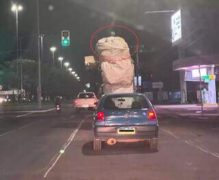 Carro lotado leva homem sobre carga em avenida da Capital