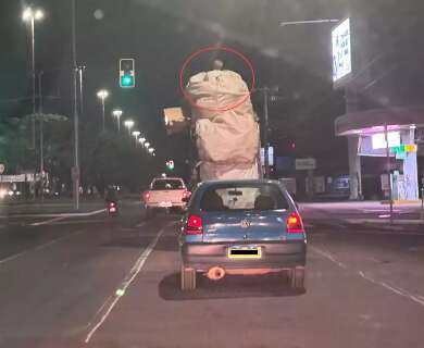 Carro lotado leva homem sobre carga em avenida da Capital