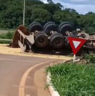 Carreta tomba em rotat&oacute;ria, carga de areia fica na pista e ve&iacute;culo destru&iacute;do