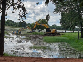 Escavadeira usada para limpar lagoa atola e afunda em brejo