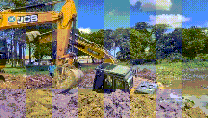Escavadeira usada para limpar lagoa atola e afunda em brejo