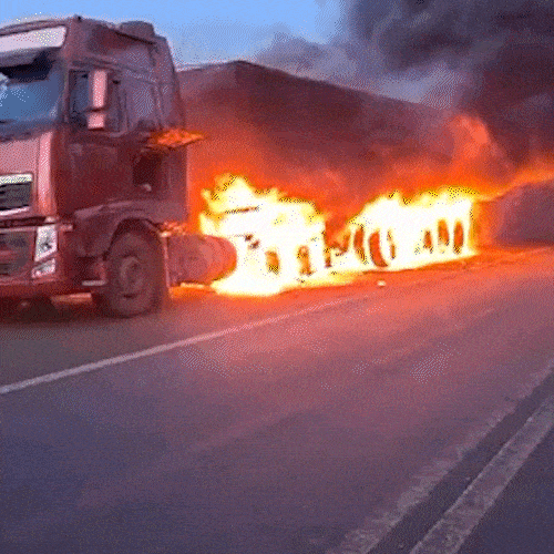 Carreta carregada com min&eacute;rio de ferro pega fogo e forma nuvem preta de fuma&ccedil;a