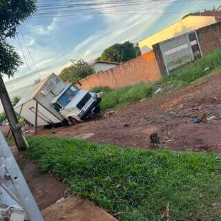 Caminh&atilde;o cai em buraco e moradores denunciam abandono em rua sem asfalto
