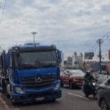 Caminh&atilde;o-cegonha estaciona sobre a faixa amarela e tumultua tr&acirc;nsito 