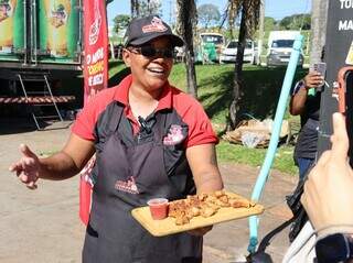 No festival do torresmo, simpatia de Letícia "vende" mais que a carne No festival do torresmo, simpatia de Letícia "vende" mais que a carne