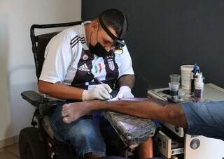 Cadeira de rodas virou apelido, mas nunca o impediu de ser tatuador Cadeira de rodas virou apelido, mas nunca o impediu de ser tatuador