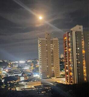 Do alto de pr&eacute;dio e na estrada, Lua de Morango colore o c&eacute;u em tom de fogo