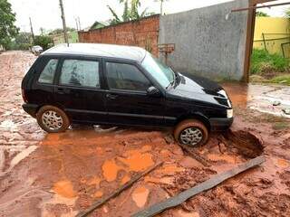 Veículo cai em vala aberta por erosão durante temporal no Jardim Batistão Veículo cai em vala aberta por erosão durante temporal no Jardim Batistão
