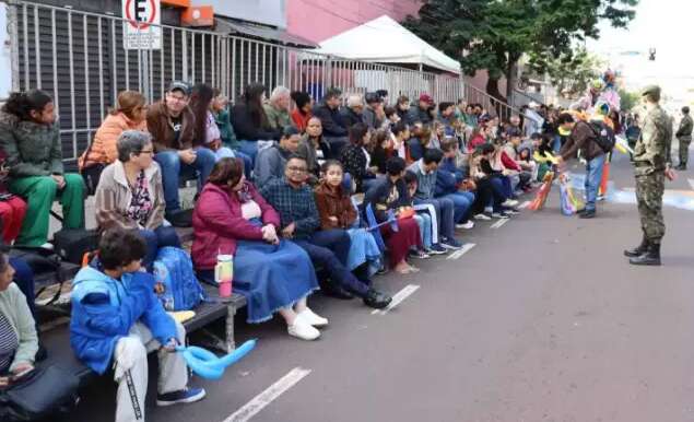 Com cobertores e casacos, p&uacute;blico enfrenta frio para acompanhar desfile c&iacute;vico 