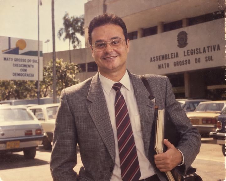 Fábio Trad – Na versão criada por IA, Fábio Trad ganhou terno, gravata, óculos e pasta de documentos em uma cena com jeitão dos anos 80.