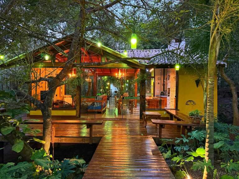 Casa se esconde entre árvores e tem até piscina no meio da mata