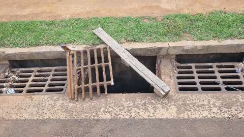 Peda&ccedil;o de madeira &eacute; sinal de alerta em grade danificada e bueiro aberto