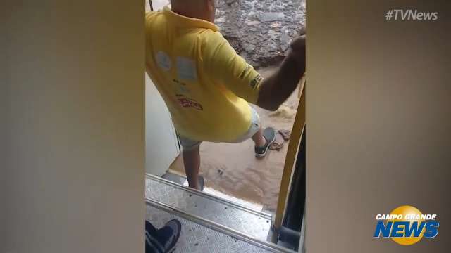 Passageiros improvisam passagem pela água após ônibus ficar atolado