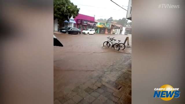 Em meia hora, chuva invade comércio, arranca asfalto e derruba muro de cemitério