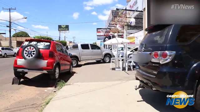 Carros bloqueiam calçada e pedestres precisam entrar na rua