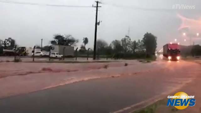 Chuva forte provoca alagamento e deixa carro ilhado em rotatória