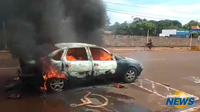 Carro é consumido pelo fogo no meio da rua