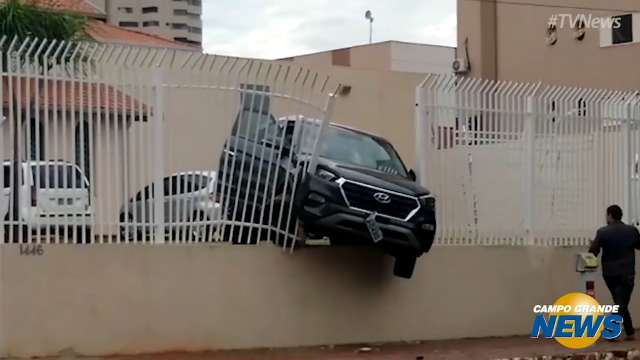 Carro fica pendurado após destruir grade de igreja no Centro