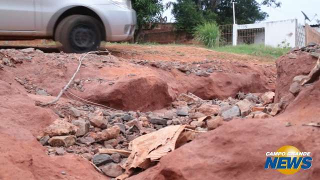 Asfalto não chega e moradores tampam crateras com entulho no Nova Lima